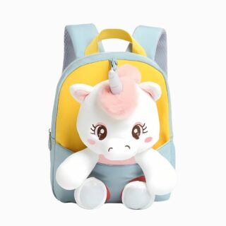 Cartable petite section avec peluche amovible. Le sac est bleu clair et jaune avec une peluche licorne assise avec les pattes qui dépassent du sac. Sur fond gris clair.
