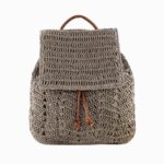 Cartable femme en paille tressée de couleur grise avec des cordons de serrage en cuir synthétique marron. Sur fond gris clair.