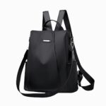 Cartable femme sac à dos avec bandoulière amovible noir. Bretelles et bandoulière accrochées avec un mousqueton. Sur fond gris clair.