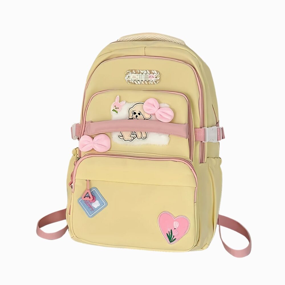 Cartable kawaii jaune pour fille avec des détails roses ( les coutures, des nœuds et un cœur). Sur fond gris clair.