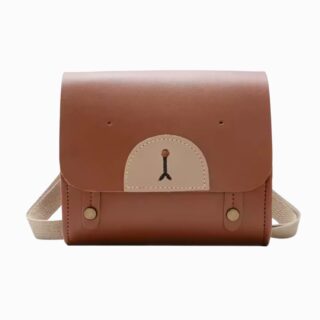Cartable maternelle en similicuir marron avec un museau d'ourson sur le devant et des bretelles beige. Sur fond gris clair.