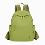 Cartable pour femme vert anis avec une poche frontale et deux espaces no fermés sur les côtés. Sur fond gris clair.