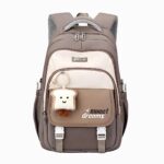 Cartable sac à dos CM1 marron avec un porte clé en forme de tranche de pain de mie. La poignée est renforcée. Sur fond gris clair.