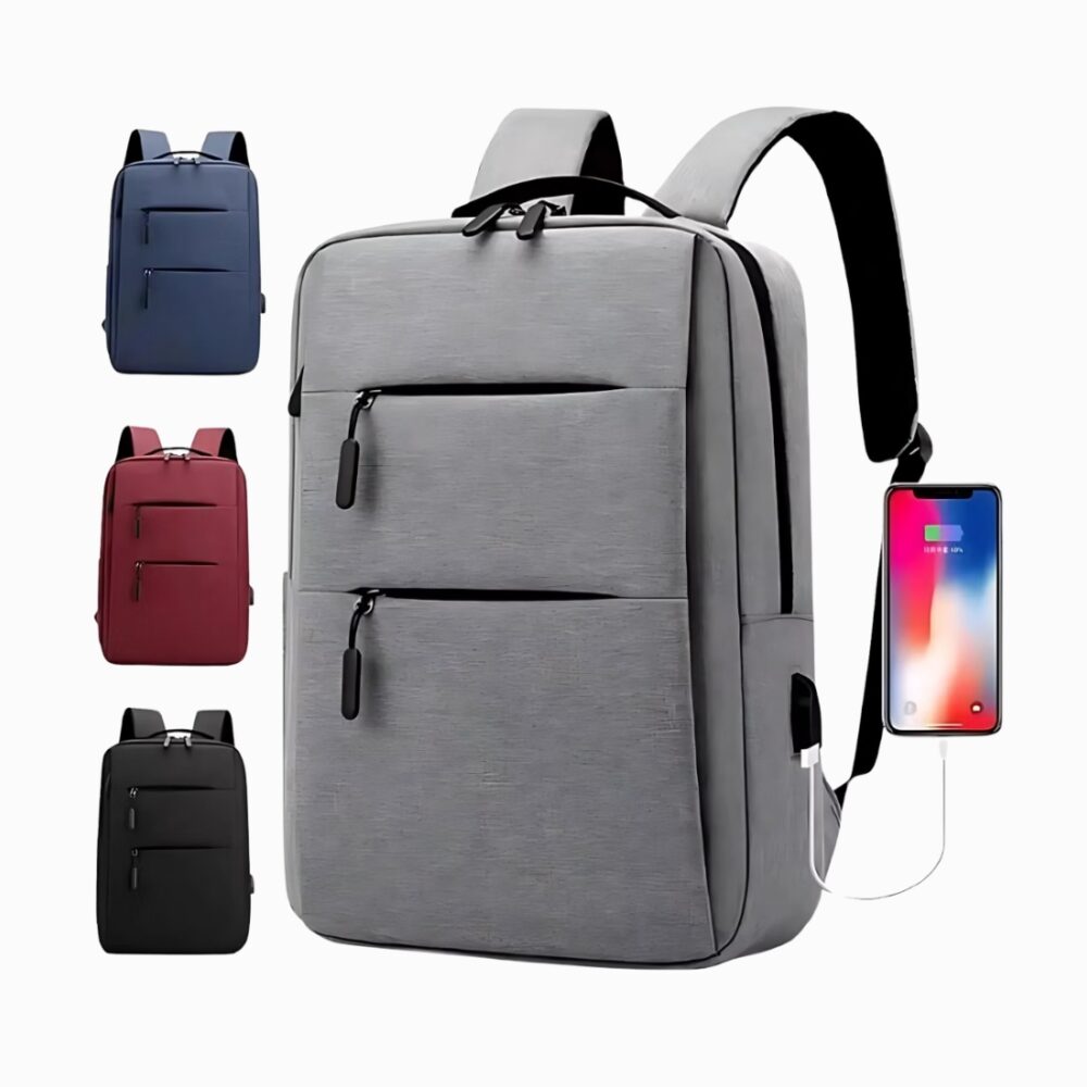 Cartable sac à dos avec branchement USB avec deux poches frontales, de couleur grise avec un téléphone branché sur la droite. Le même modèle sur la gauche en bleu, rouge et noir. Sur fond gris clair.