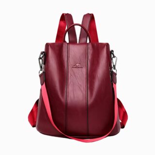 Cartable sac à dos bordeaux avec bandoulière pour femme. Sur fond gris clair.