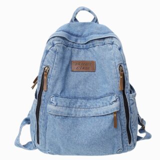 Cartable sac à dos en jean clair avec une poche frontale et deux fermeture zippée de chaque côté. Sur fond gris clair.
