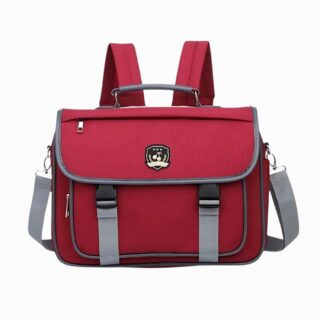 Cartable sac à dos style japonais de couleur bordeaux avec un détail style blason. Poignée, bretelles et bandoulière. Sur fond gris clair.