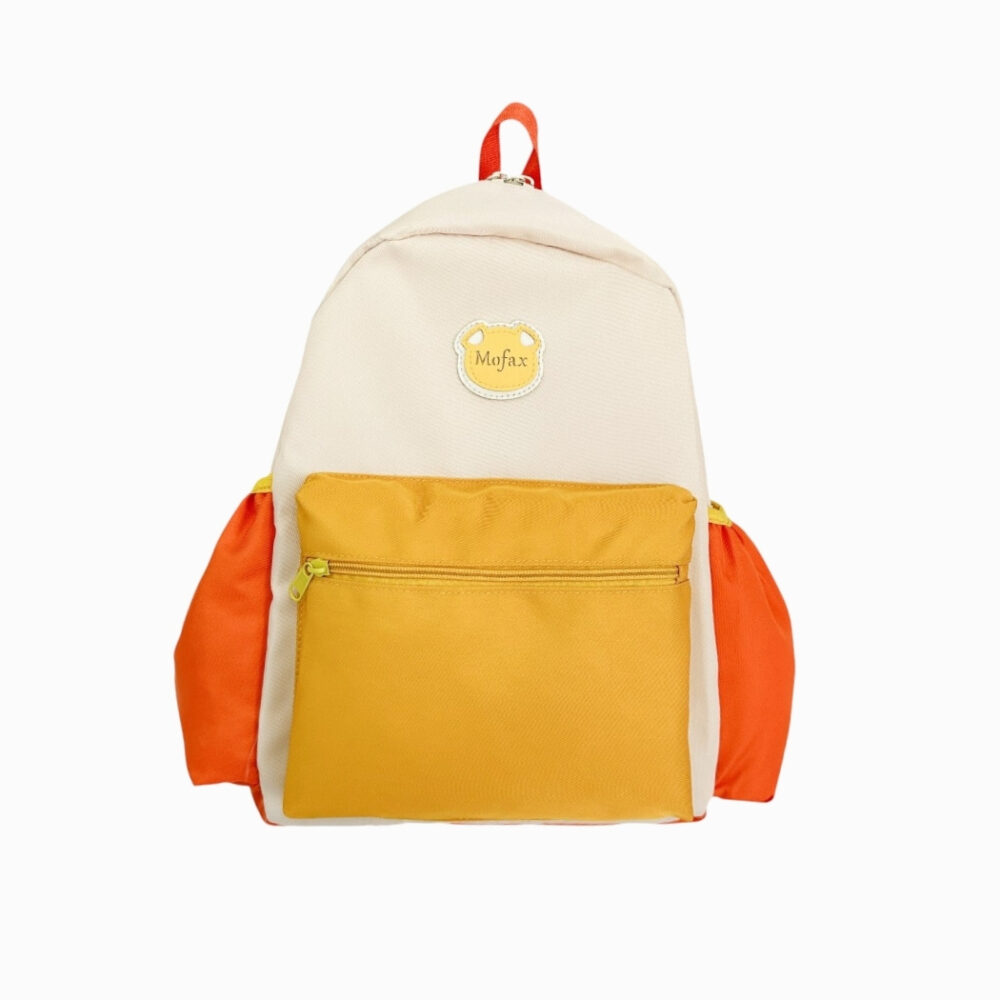 Cartable 24x32x cm coloré pour la maternelle. Les poches élastiques de chaque côté sont oranges, la poche frontale est jaune, le reste est blanc cassé sauf la poignée qui est orange. Sur fond gris très clair uni.