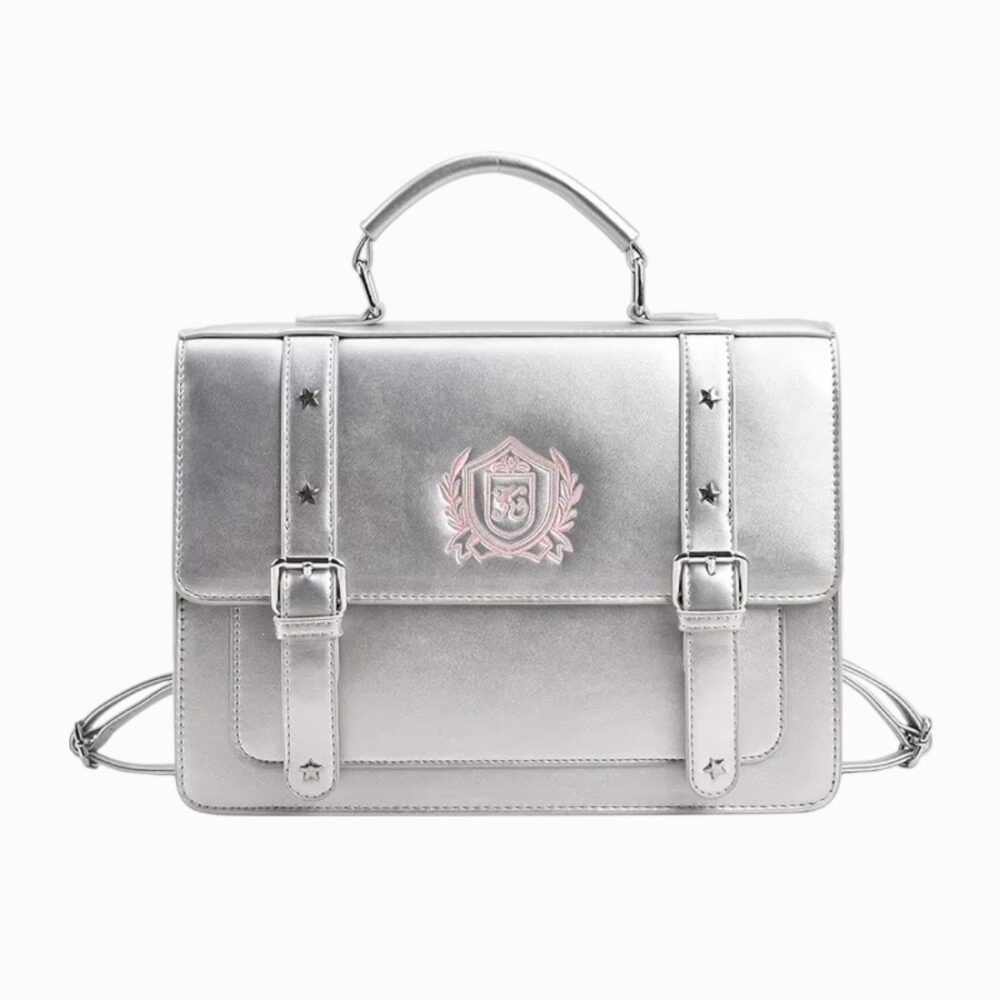 Cartable rigide argenté avec écusson, deux boucles décoratives et anse arrondie, dans un style japonnais retro, sur fond neutre.