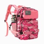Cartable style tactique camouflage rose avec plusieurs compartiments zippés et des filets avec une gourde sur les côté. Bretelles rembourrées. Sur fond gris clair.