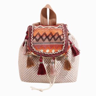 petit sac à dos en paille beige, rabat brodé de motifs colorés, pompons suspendus, fond blanc.
