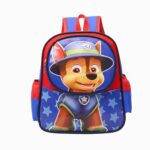 Un cartable Pat’Patrouille Chase bleu et rouge avec la tête de Chase sur le devant, des étoiles bleues en fond et deux bretelles pour le porter à l’école.