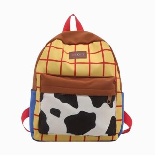 Un cartable Toy Story pour maternelle aux couleurs de Woody, avec un fond jaune à carreaux rouges, une poche blanche et noire façon vache, et des bretelles rouges.