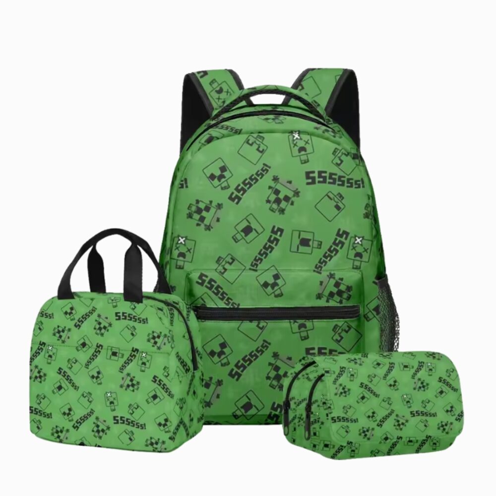Un cartable Minecraft vert avec trousse et sac repas, imprimé de petits motifs carrés noirs, posé avec sa trousse et son sac repas assortis sur fond blanc.
