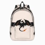 Un cartable Pokémon avec la silhouette de Dracaufeu beige et noir, avec une grande poche devant et des bretelles pour le porter à l’école.