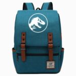 Un cartable Jurassic World à rabat bleu avec logo de dinosaure blanc, deux boucles marron et une poche avant, posé sur fond blanc.