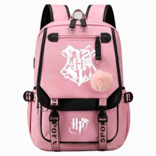 Un cartable Harry Potter rose avec écussons des 4 maisons, vu de face, avec bretelles noires et pompon rose, posé sur un fond blanc.